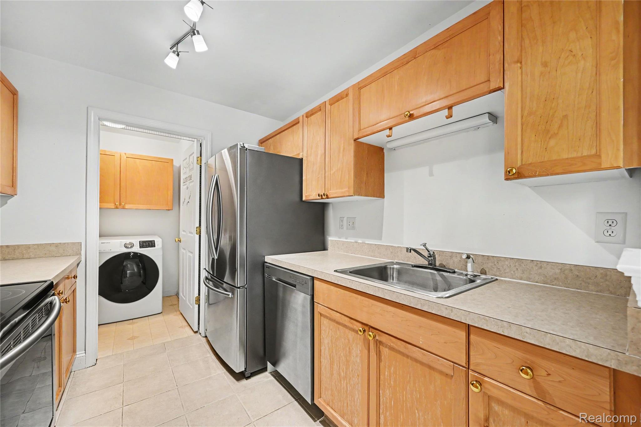 3633 Oakmonte Boulevard, Unit 189 Rochester, MI 48306 - Photo 22 of 36 Kitchen featuring light wood cabinetry and countertops, stainless steel appliances, and tile flooring