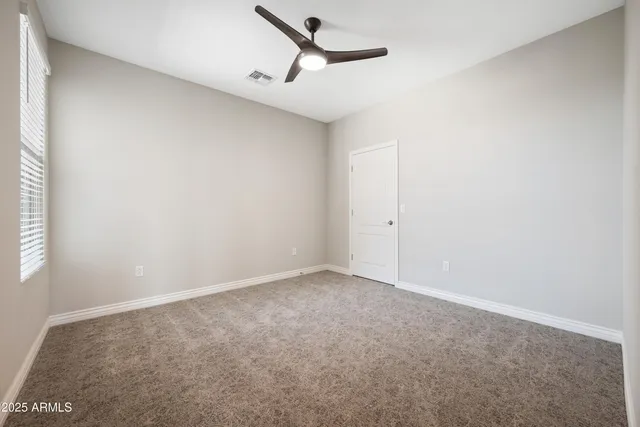 an empty room with closet and windows
