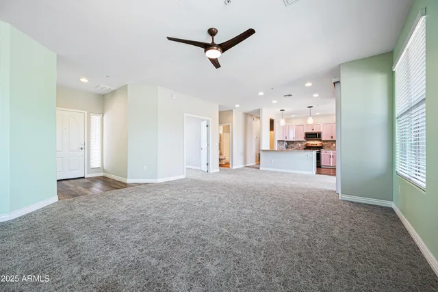 a view of empty room with wooden floor and a window