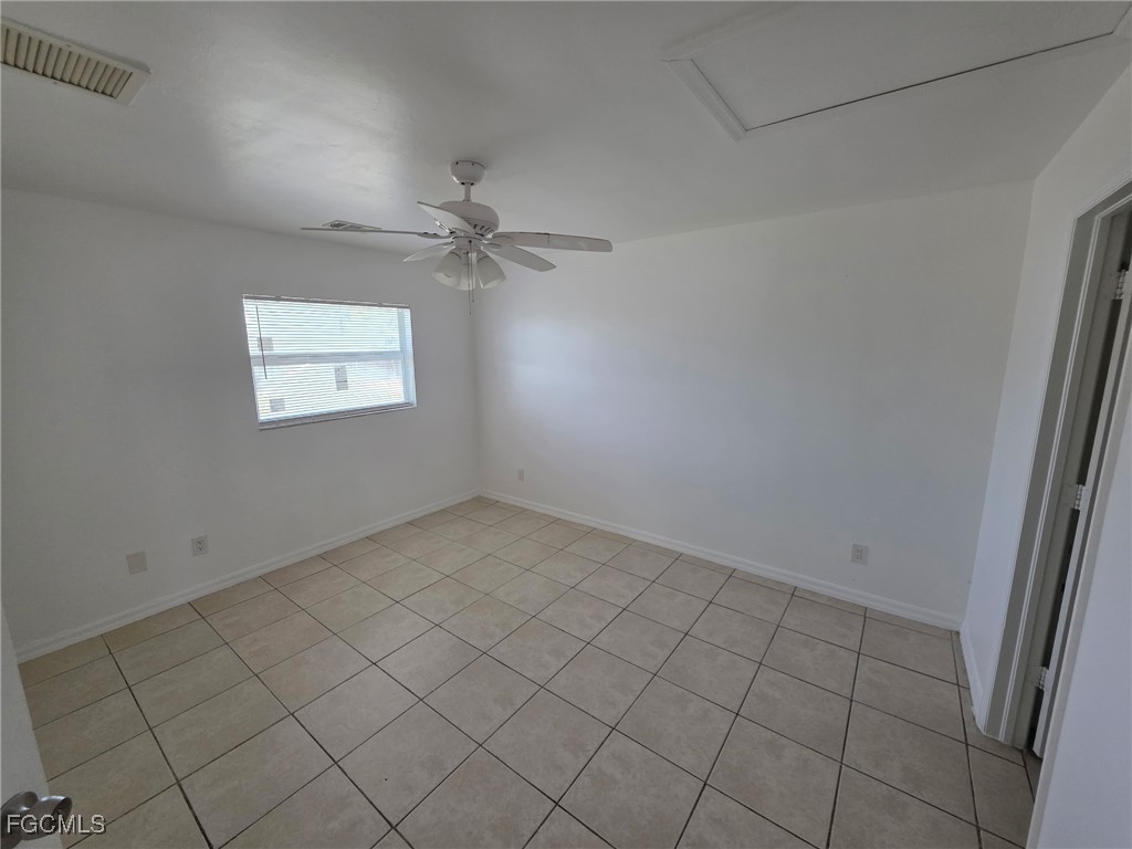 1248 Columbus Boulevard, Unit B Fort Myers, FL 33913 - Photo 6 of 16 an empty room with windows and fan