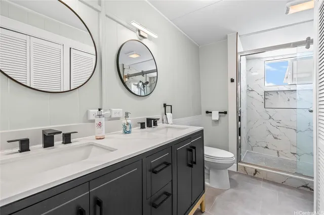 a bathroom with a double vanity sink mirror and a toilet