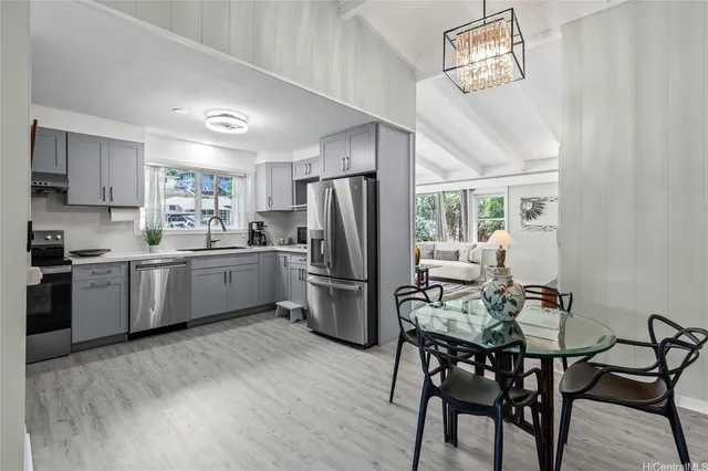 a kitchen with a table chairs refrigerator and microwave