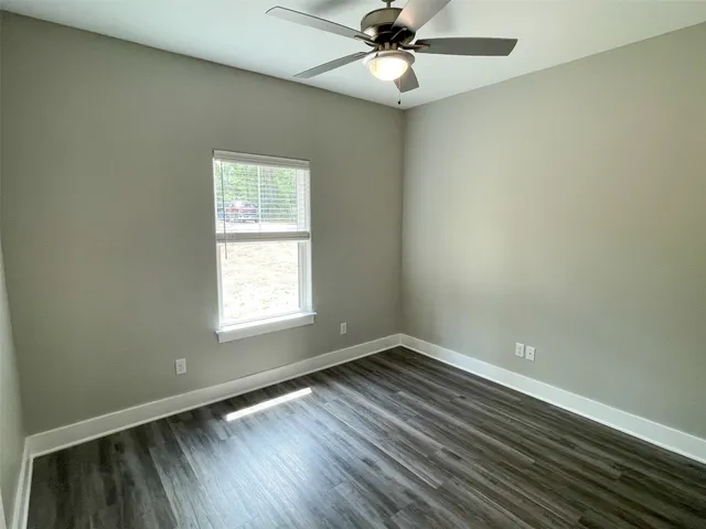 an empty room with a window and wooden floor