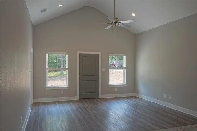 an empty room with a window and wooden floor