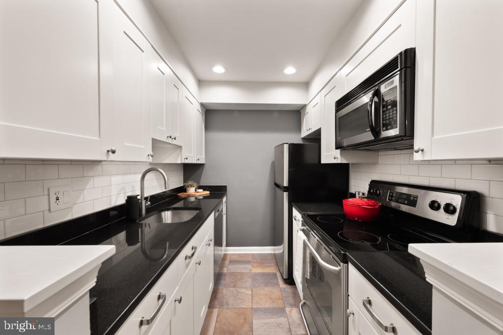1441 A Street Northeast, Unit 1441 Washington, DC 20002 - Photo 7 of 11 a kitchen with stainless steel appliances granite countertop a sink stove and refrigerator