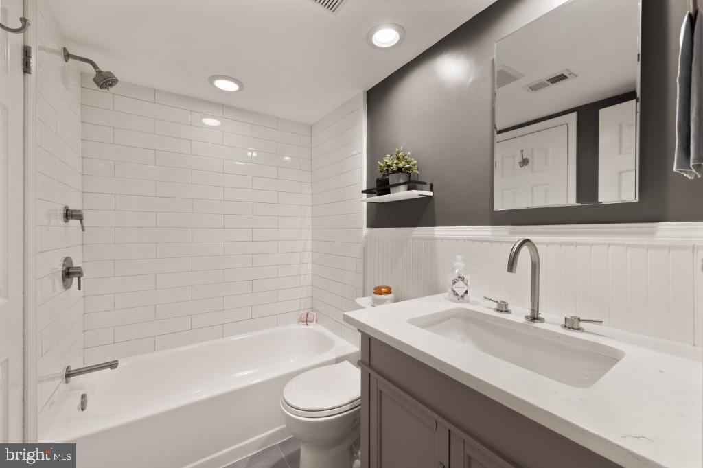 1441 A Street Northeast, Unit 1441 Washington, DC 20002 - Photo 8 of 11 a bathroom with a granite countertop sink a toilet and bathtub
