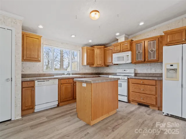 a kitchen with granite countertop wooden floors appliances and cabinets