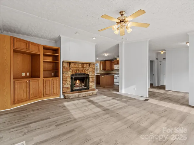 wooden floor fireplace and windows in an empty room
