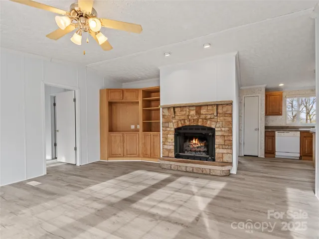 a view of a livingroom with a fireplace window and wooden floor