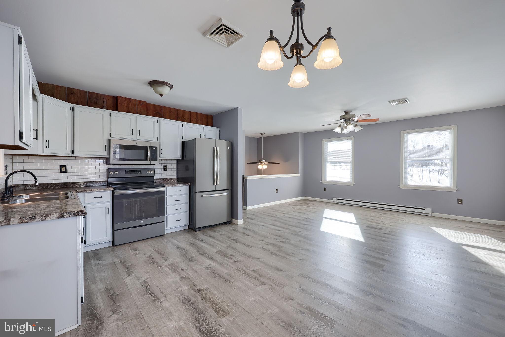 877 Richmond Road Windsor, PA 17366 - Photo 12 of 40 a kitchen with stainless steel appliances granite countertop a refrigerator a sink dishwasher a stove and white cabinets with wooden floor