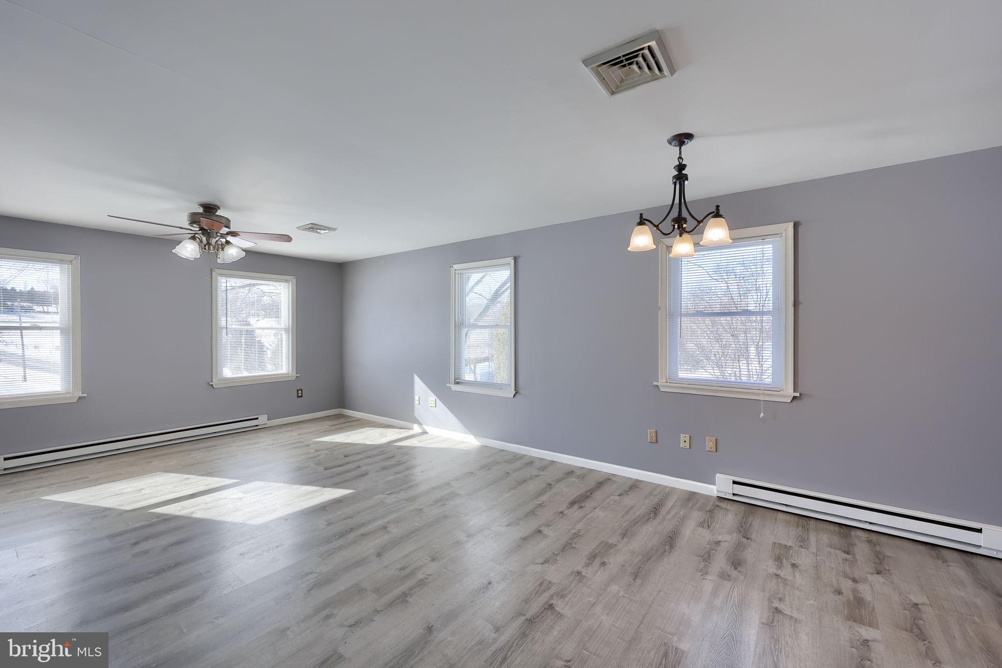 877 Richmond Road Windsor, PA 17366 - Photo 5 of 40 an empty room with wooden floor chandelier and windows