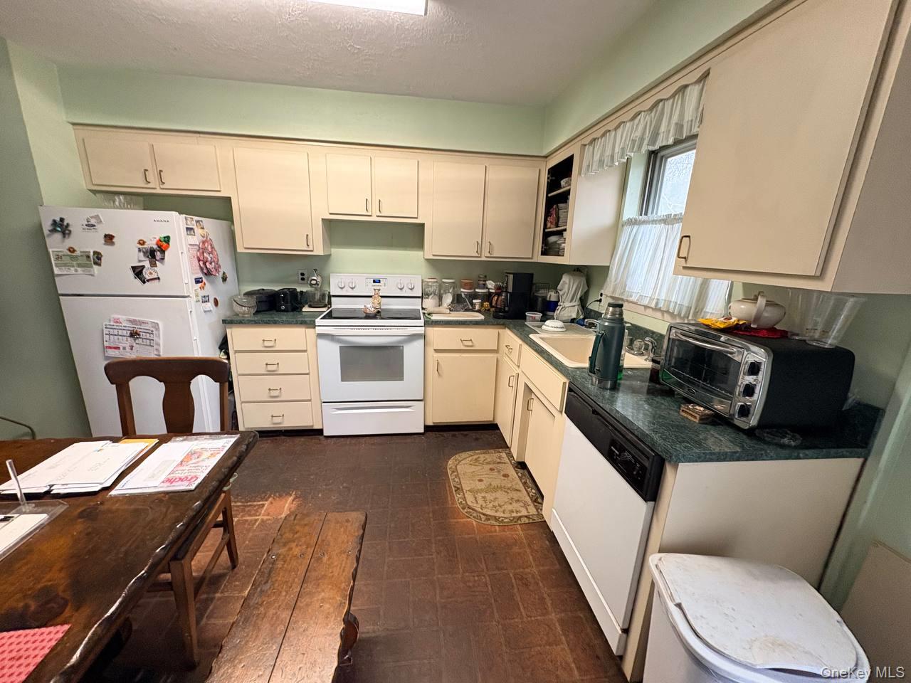 66 40th Street Islip, NY 11751 - Photo 4 of 12 a kitchen with a refrigerator a stove a sink dishwasher and white cabinets with wooden floor