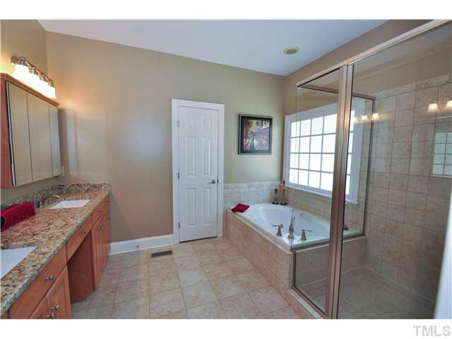 4209 White Chapel Way Raleigh, NC 27615 - Photo 13 of 25 The master bath will be your daily sanctuary! Relax in the Whirlpool tub, or grab a quick rinse in the walk-in shower. Features tile flooring, tile surround at tub, granite counter top, dual vanity, upgraded fixtures, walk-in closet and picture window.