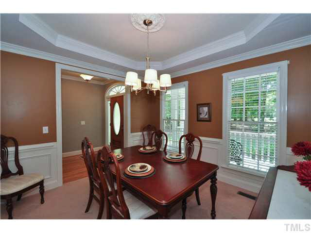 4209 White Chapel Way Raleigh, NC 27615 - Photo 5 of 25 The dining room features wainscoting, trey ceiling for added depth, lovely chandelier and designer color scheme.