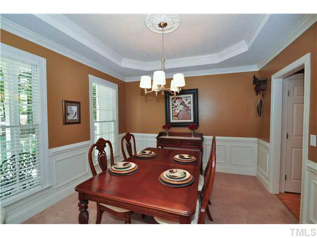 4209 White Chapel Way Raleigh, NC 27615 - Photo 6 of 25 The dining room features wainscoting, trey ceiling for added depth, lovely chandelier and designer color scheme.