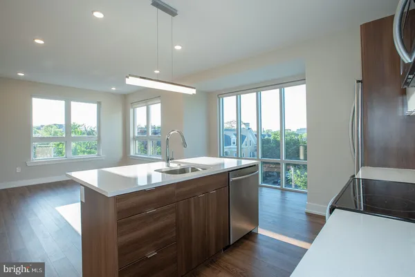 a kitchen with center island wooden floor and a large window