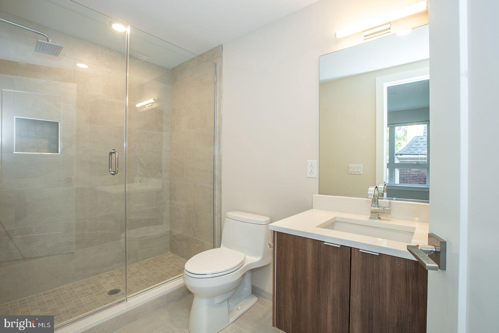 4534 Spruce Street, Unit 2BA2 Philadelphia, PA 19139 - Photo 5 of 9 a bathroom with a sink a toilet and shower