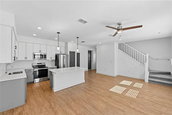 a view of kitchen with stainless steel appliances refrigerator stove microwave and cabinets