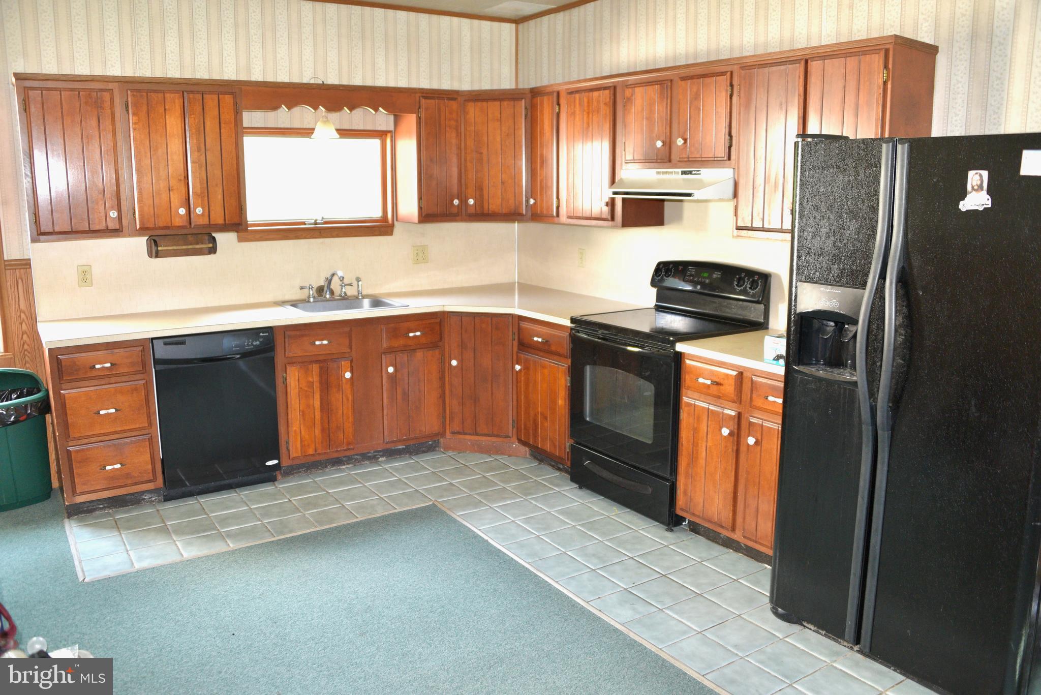722 Mohns Hill Road Reading, PA 19608 - Photo 12 of 46 a kitchen with stainless steel appliances granite countertop a refrigerator a sink dishwasher a stove with wooden cabinets and floor