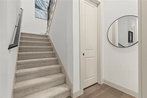 a view of staircase with white walls and white door