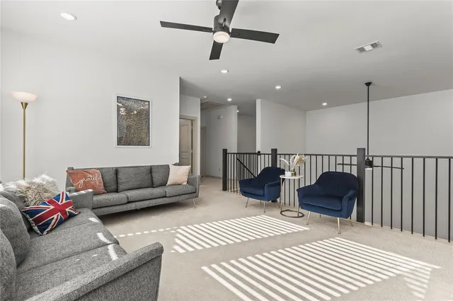 a living room with furniture and a ceiling fan