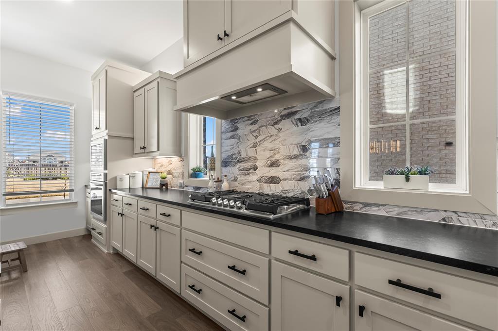 15627 Rue Drive Frisco, TX 75033 - Photo 4 of 35 a kitchen with granite countertop white cabinets and white appliances