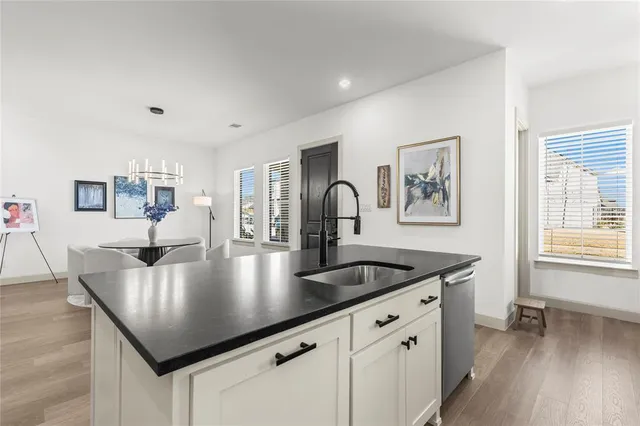 a kitchen with kitchen island stainless steel appliances a table chairs and wooden floor