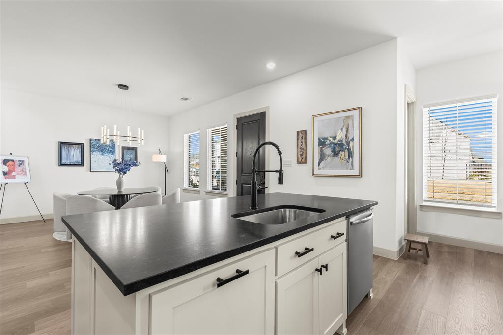15627 Rue Drive Frisco, TX 75033 - Photo 6 of 35 a kitchen with kitchen island stainless steel appliances a table chairs and wooden floor