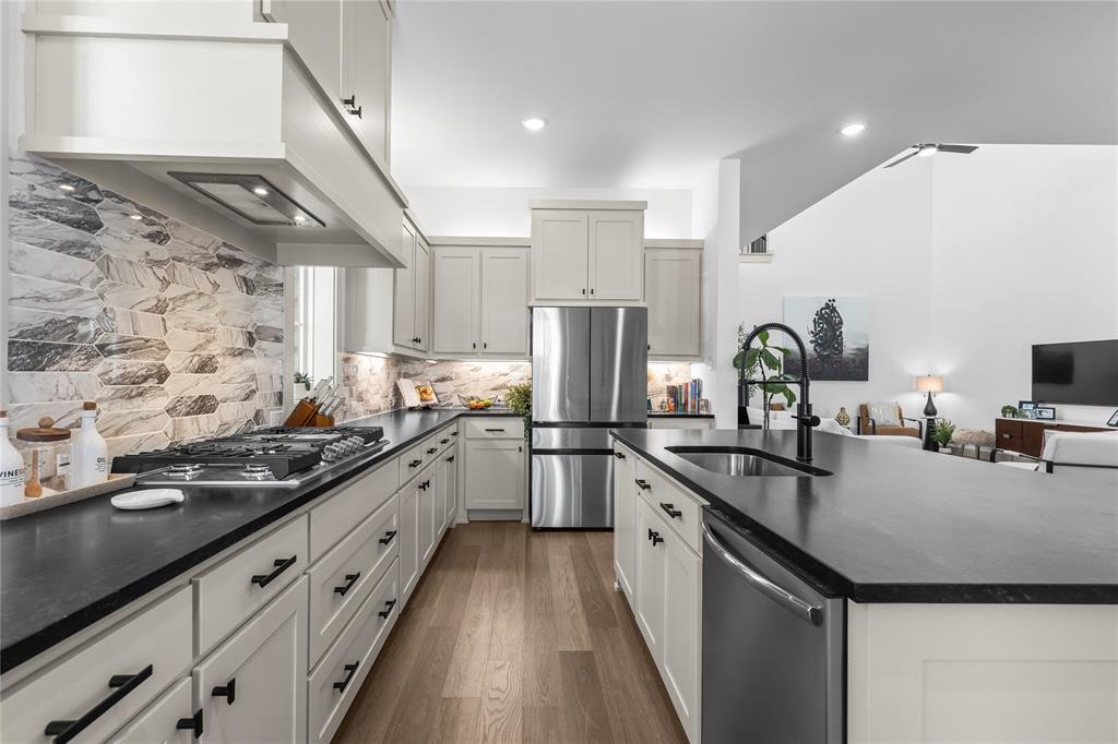 15627 Rue Drive Frisco, TX 75033 - Photo 7 of 35 a kitchen with stainless steel appliances granite countertop a sink stove and refrigerator