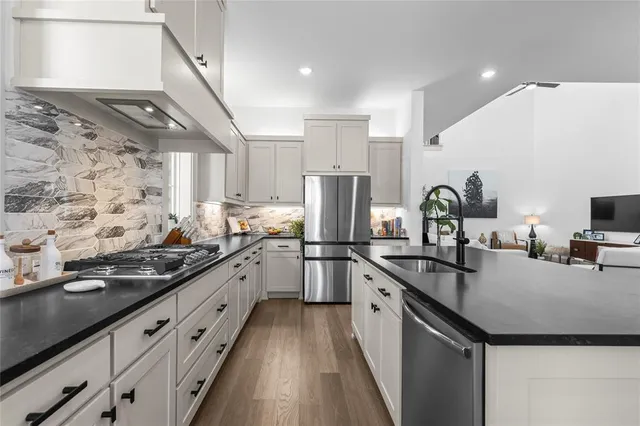 a kitchen with stainless steel appliances granite countertop a sink stove and refrigerator