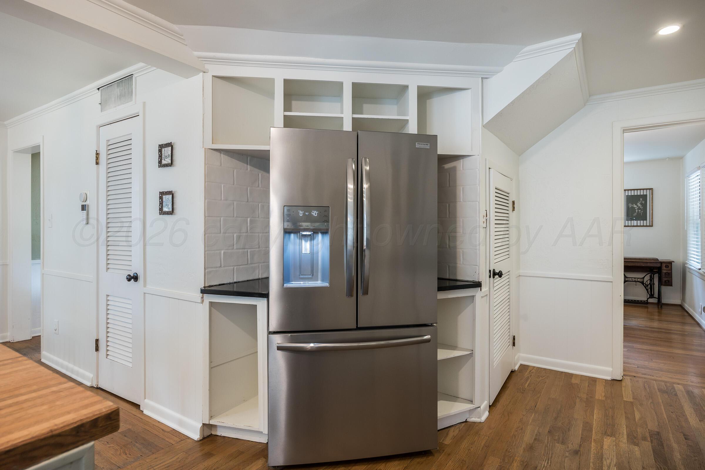 2102 South Hayden Street Amarillo, TX 79109 - Photo 18 of 44 a kitchen with stainless steel appliances a refrigerator and wooden floor