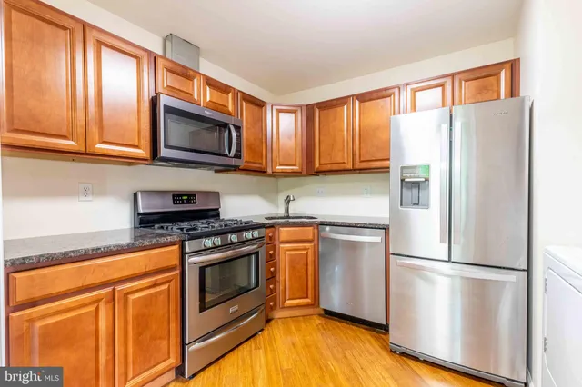 a kitchen with stainless steel appliances granite countertop a refrigerator stove microwave and sink