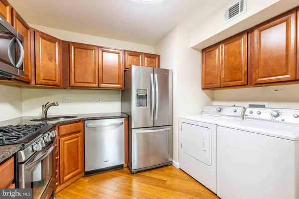 a kitchen with stainless steel appliances granite countertop a refrigerator stove and sink