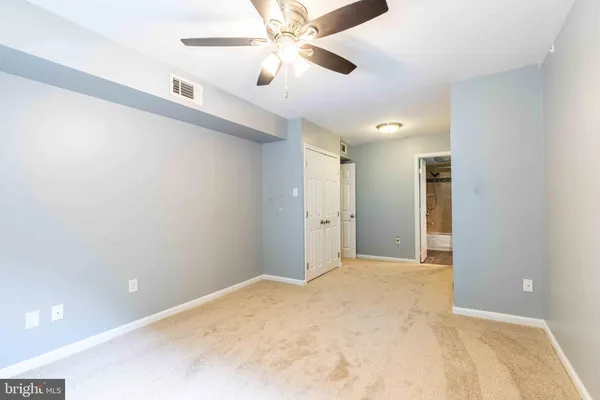 a view of a big room with closet and a ceiling fan