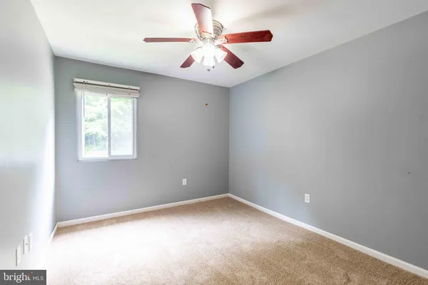 an empty room with window and ceiling fan