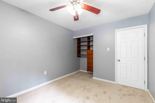 an empty room with closet and windows