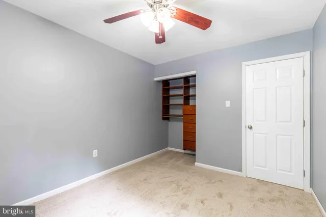an empty room with closet and windows