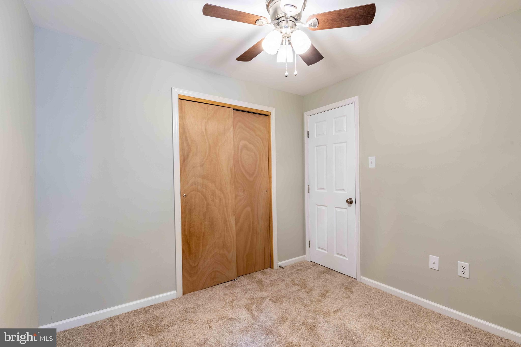 704 Painters Crossing, Unit 704 Chadds Ford, PA 19317 - Photo 21 of 34 an empty room with a chandelier fan and closet area