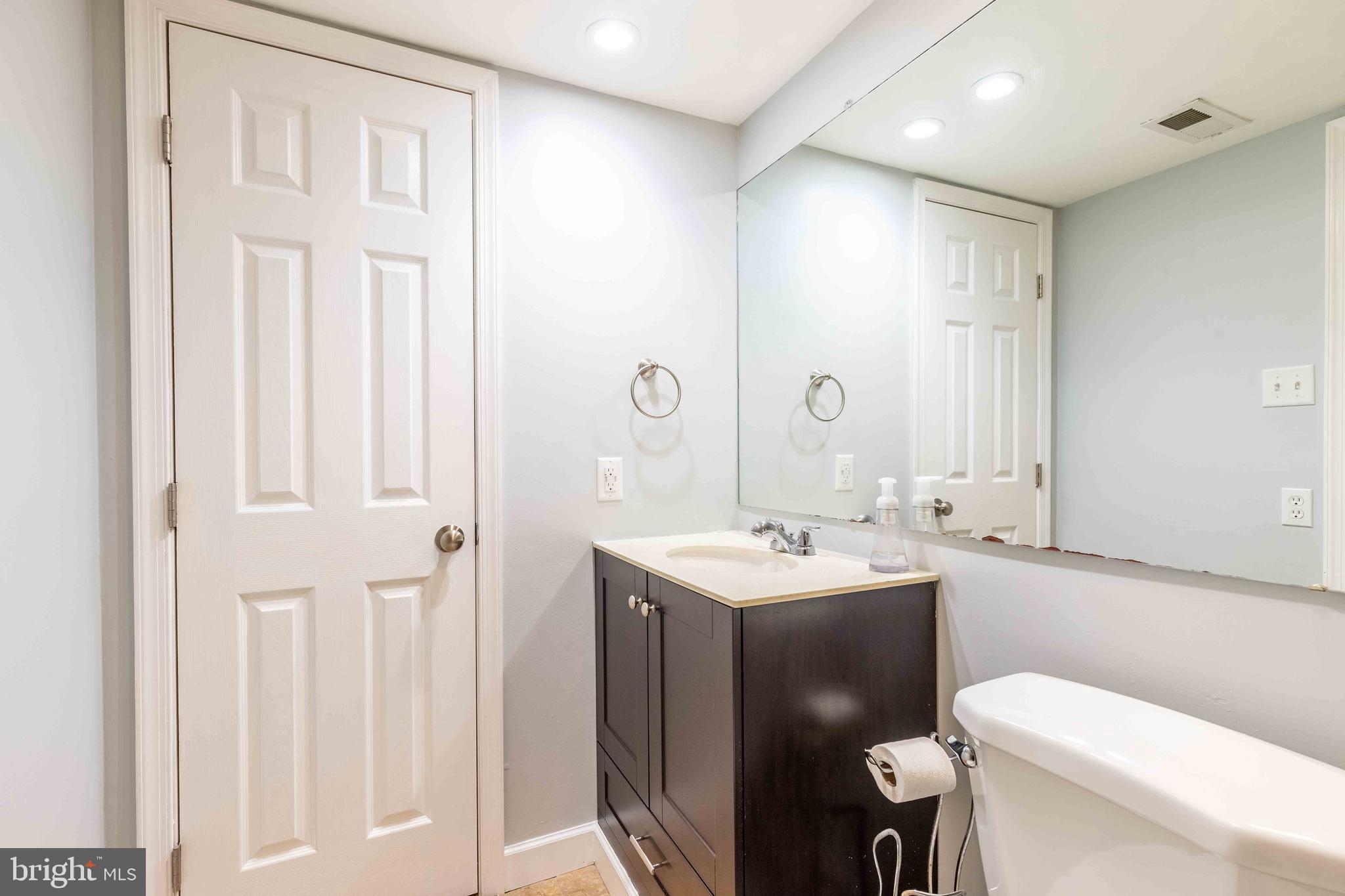 704 Painters Crossing, Unit 704 Chadds Ford, PA 19317 - Photo 22 of 34 a bathroom with a toilet sink vanity and mirror