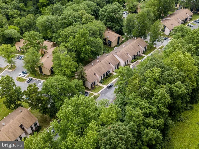 an aerial view of residential house with outdoor space and trees all around