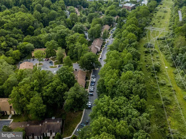 an aerial view of residential house with outdoor space and trees all around
