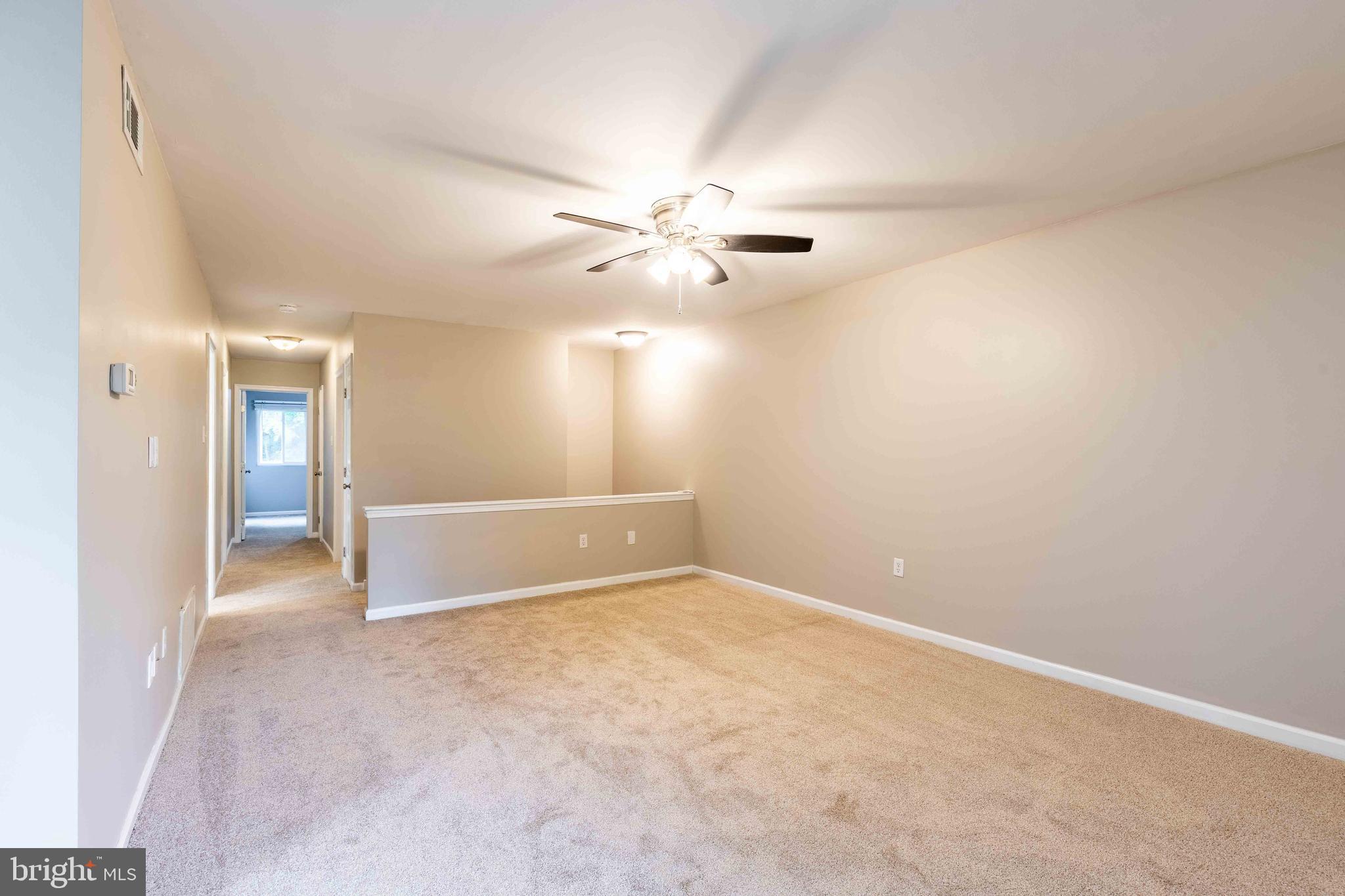 704 Painters Crossing, Unit 704 Chadds Ford, PA 19317 - Photo 5 of 34 an empty room with chandelier fan and windows