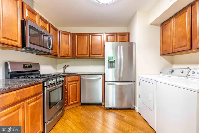a kitchen with stainless steel appliances granite countertop a refrigerator stove top oven and sink