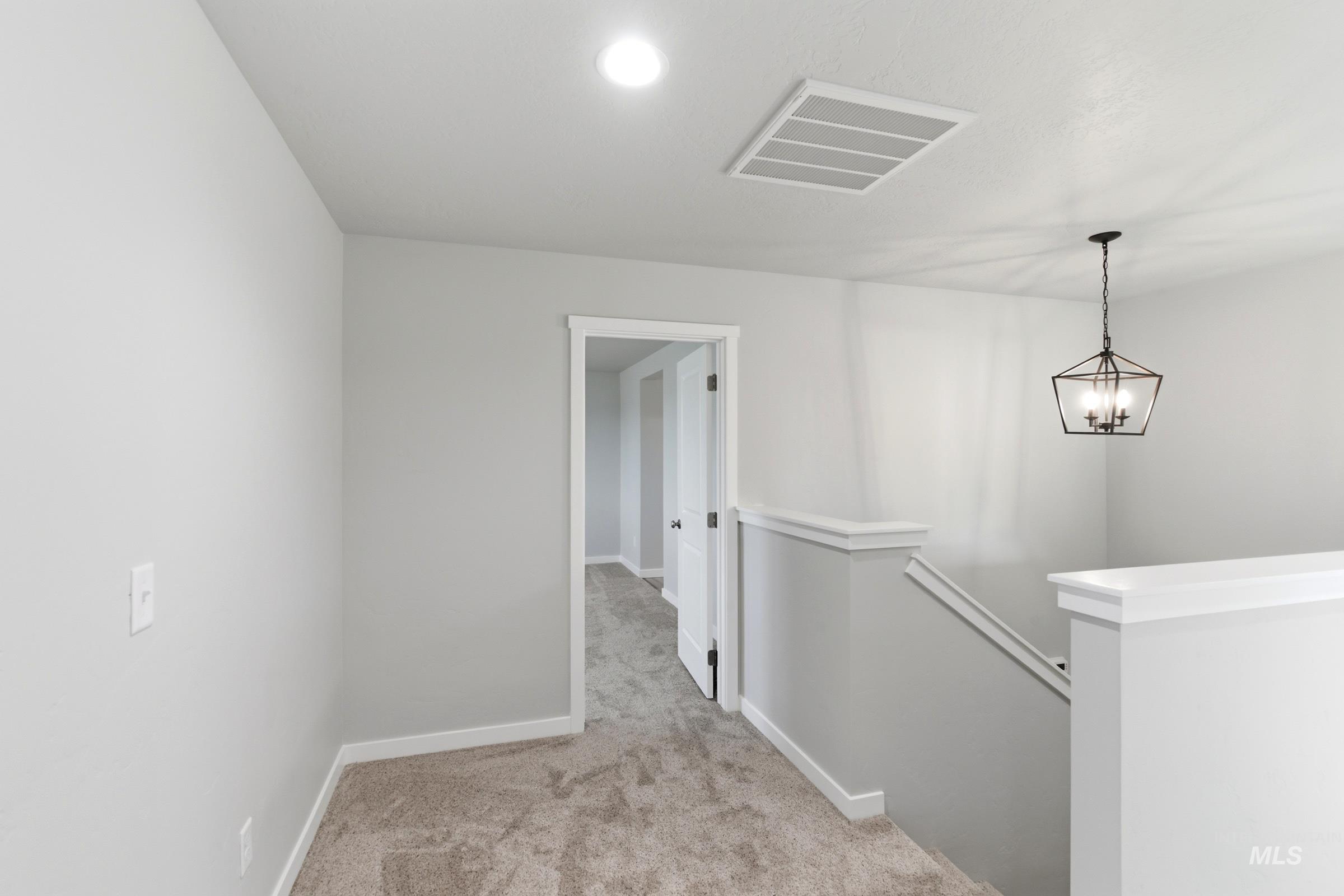 13709 Redway Court Caldwell, ID 83607 - Photo 13 of 28 Upper-level landing featuring neutral carpeting, white trim, a matte black geometric chandelier, recessed lighting, and an open doorway