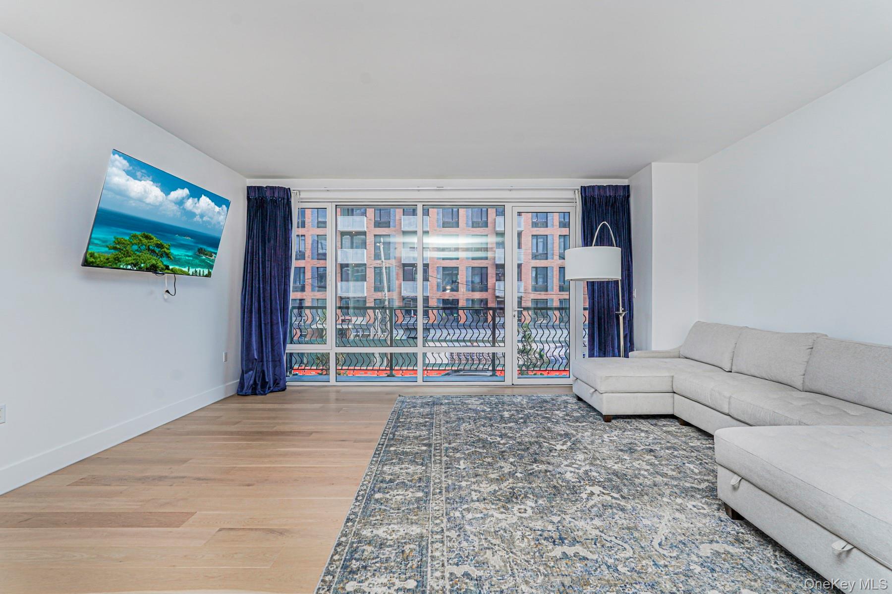 133 Beach 116th Street, Unit 2C Queens, NY 11694 - Photo 13 of 35 a living room with furniture and a flat screen tv