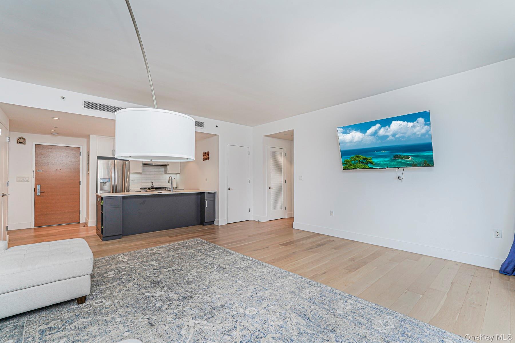 133 Beach 116th Street, Unit 2C Queens, NY 11694 - Photo 15 of 35 a living room with furniture a flat screen tv and kitchen view