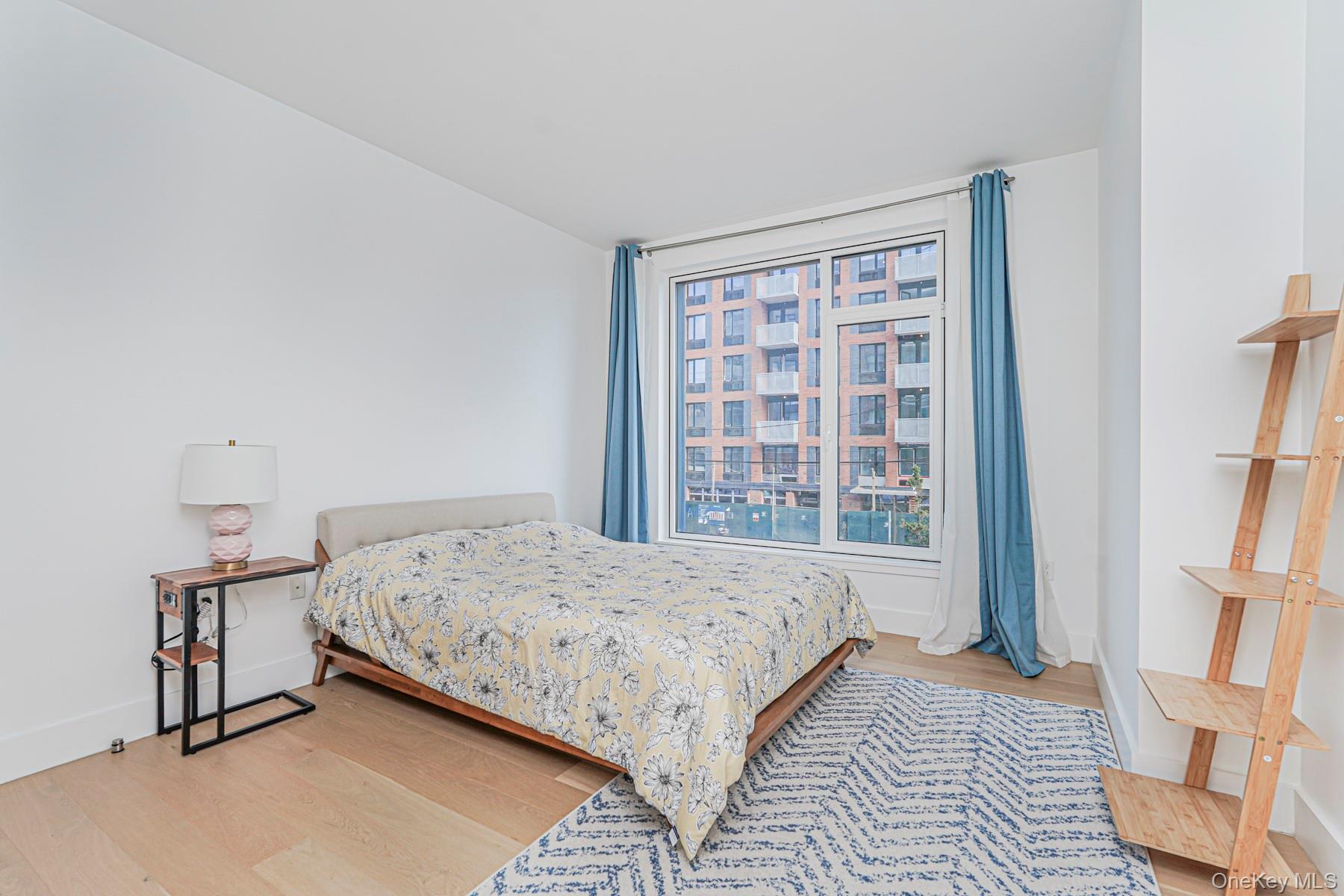 133 Beach 116th Street, Unit 2C Queens, NY 11694 - Photo 18 of 35 a bedroom with a bed next to a large window
