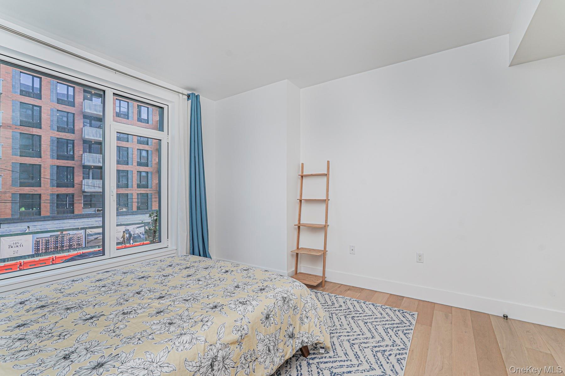 133 Beach 116th Street, Unit 2C Queens, NY 11694 - Photo 19 of 35 a bedroom with a bed and a large window