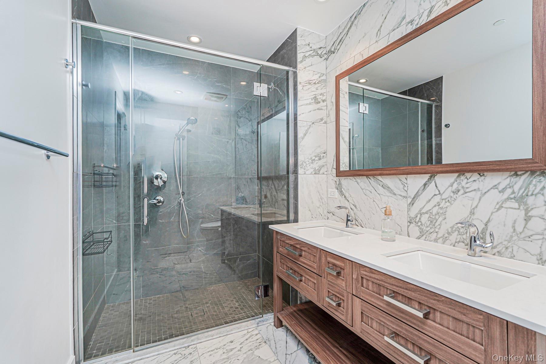 133 Beach 116th Street, Unit 2C Queens, NY 11694 - Photo 28 of 35 a bathroom with a double vanity sink mirror and shower