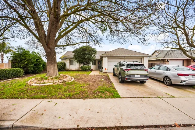 a front view of a house with a garden and trees
